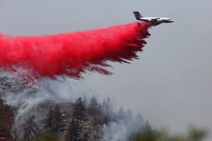 A firefighting aircraft flies over a wildfire near Hesperia, California in August 2016.