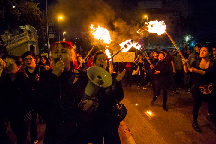 Women carrying torches during a march in Santiago, Chile to protest against femicide and gender violence.