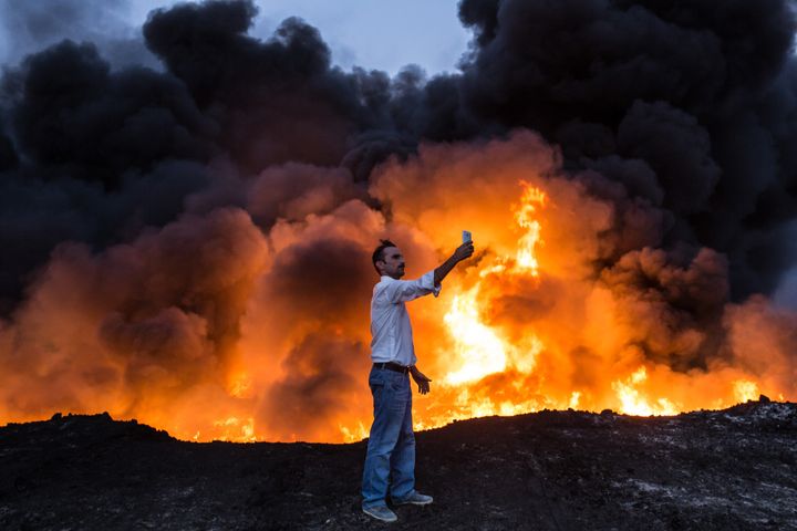 A man takes a selfie in front of oil that has been set ablaze in the Qayyarah area of Iraq, some 35 miles south of Mosul, on Thursday during an Iraqi forces operation against Islamic State militants in the battle for the key city.