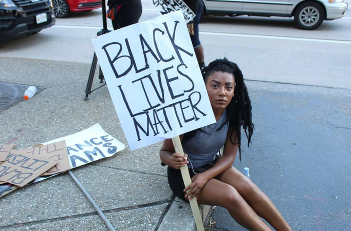 <p>Rachael Edwards holds a Black Lives Matter picket sign during a protest of Baltimore's Fraternal Order of Police annual conference, on August 14, 2016 in Baltimore, Maryland</p>