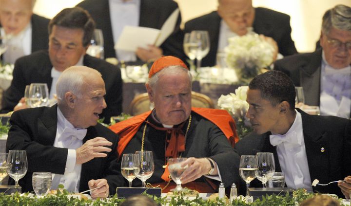 Sen. John McCain (R-Ariz.), left, chats with then-Sen. Barack Obama (D-Ill.) at the Al Smith dinner in October 2008. Cardinal Egan, the then-archbishop of New York, looks on.