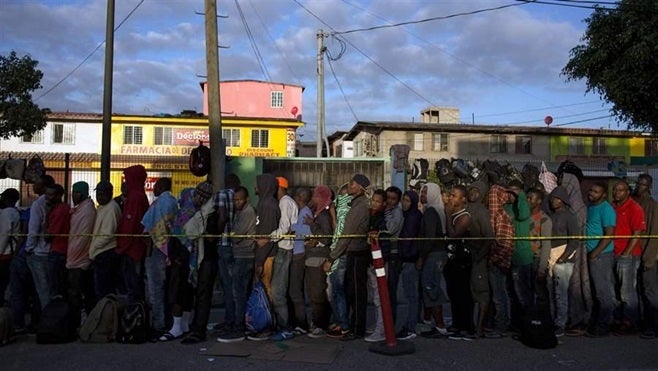 Haitian and African migrants seeking asylum in the U.S. line up outside a migration office in Tijuana, Mexico. Haitians are flooding the border south of San Diego, prompting the U.S. to resume deportations for those who do not qualify for asylum.