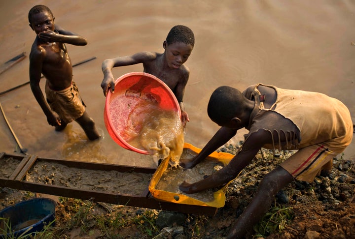 Boys pan for gold on a riverside at Iga Barriere in eastern Congo.