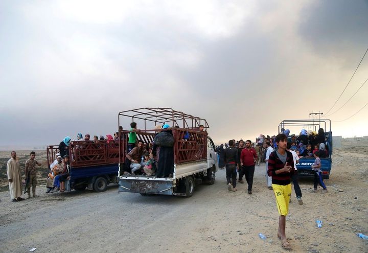 Smoke rises as people flee their homes during clashes between Iraqi security forces and members of the Islamic State group fleeing Mosul, Iraq, Tuesday, Oct. 18, 2016.