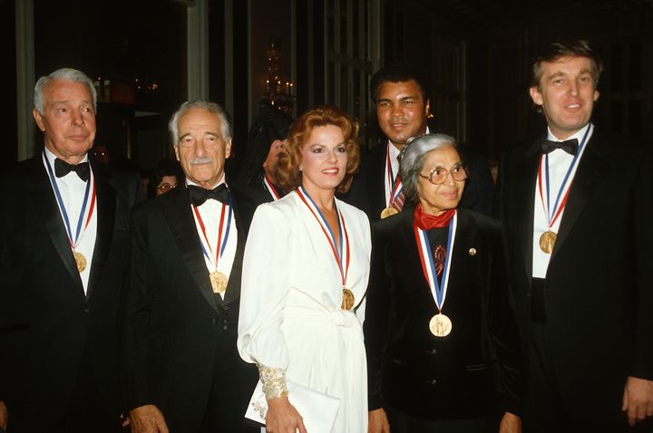 (Left to Right) Joe DiMaggio, Victor Borge, Anita Bryant, Muhammad Ali, Rosa Parks, and Donald Trump pose for a photograph after receiving the Ellis Island Medal of Honor October 27, 1986 in New York City.