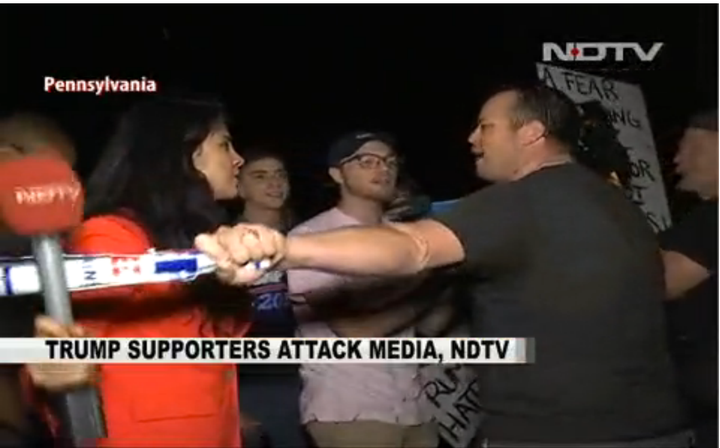 A Donald Trump supporter outside a campaign rally in Newtown, Pennsylvania, bats away NDTV reporter Namrata Brar's microphone.