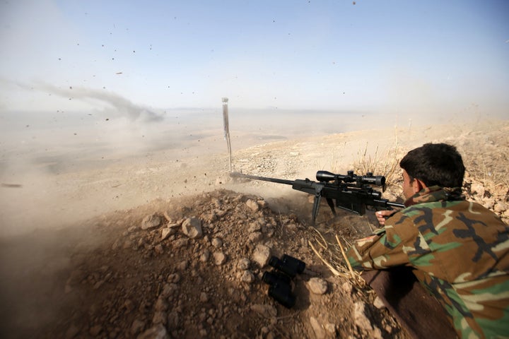 A Kurdish peshmerga fighter shoots during an operation to attack Islamic State militants in the town of Naweran, near Mosul,