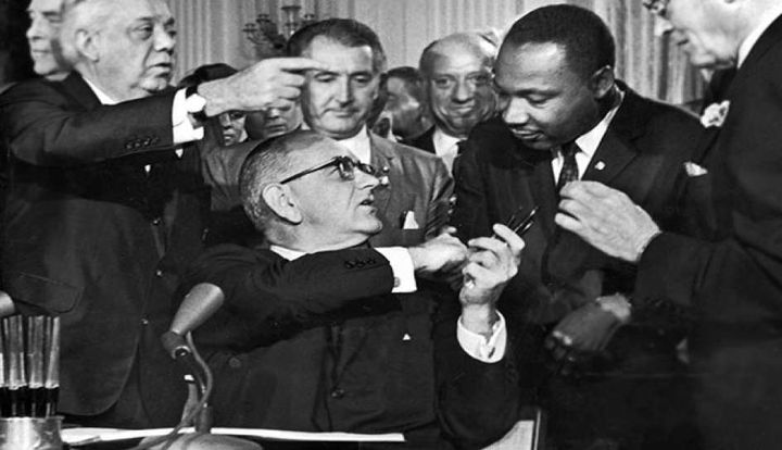 President Johnson hands Martin Luther King one of the pens he used to sign the historic 1964 Civil Rights Act.