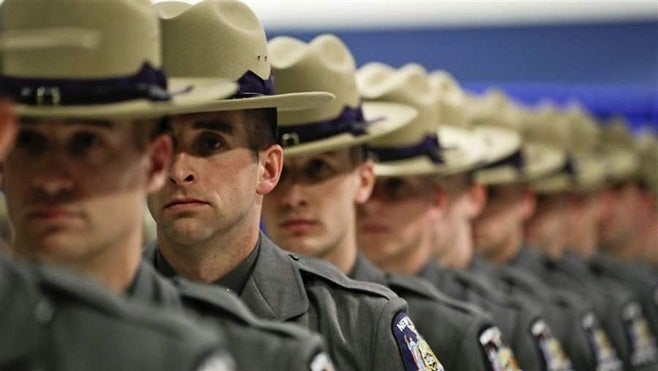 Graduating New York State Police officers line up during a ceremony in Albany. State police often leave the force for higher-paying jobs at city departments.