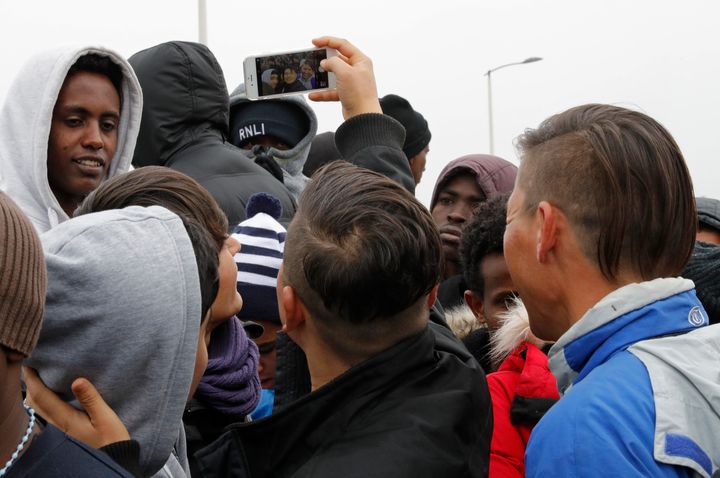 Migrants queue at the start of the evacuation of 'The Jungle' camp in Calais, France on Monday
