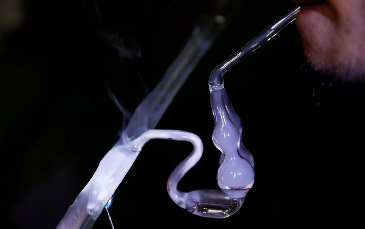 A drug addict uses a glass water pipe to smoke shabu, or methamphetamine, at an undisclosed drug den in Manila, Philippines June 20, 2016.