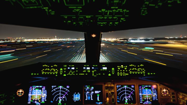 Living In The Age of Airplanes - a shot of the cockpit during a night landing