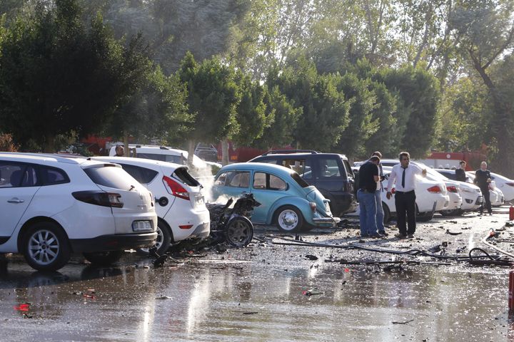 People stand by damaged cars near the site of an explosion in Antalya on Tuesday