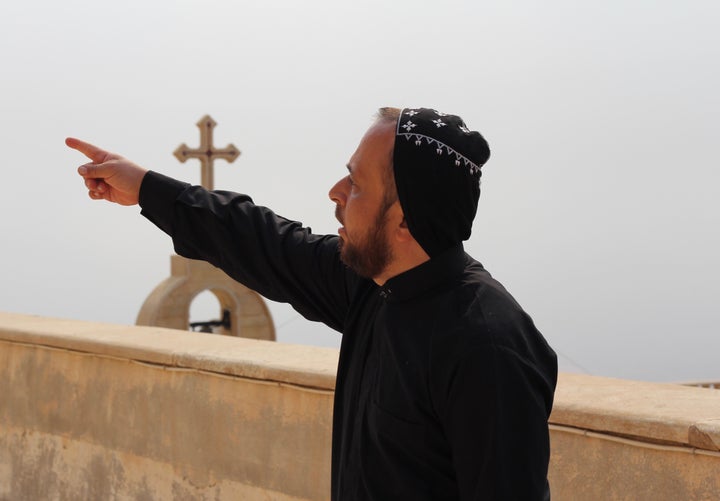 The Rev. Thomas stands on the roof of Mar Mattai -- a reportedly 1600-year-old Christian monastery, known as one of the oldest in the world -- as U.S.-led airstrikes pound Islamic State positions in the distance.