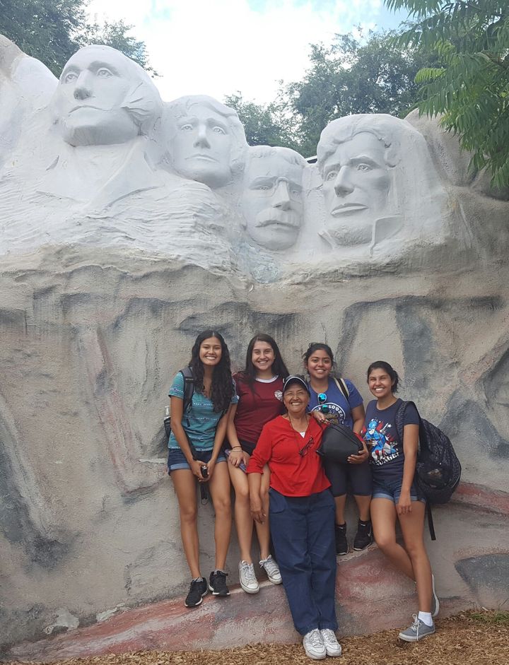 Cassandra Ruiz (L) with her family in South Dakota, posing with a miniature Mt. Rushmore. 