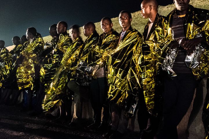 Migrants rescued by the Italian Coast Guard disembark onto Lampedusa.