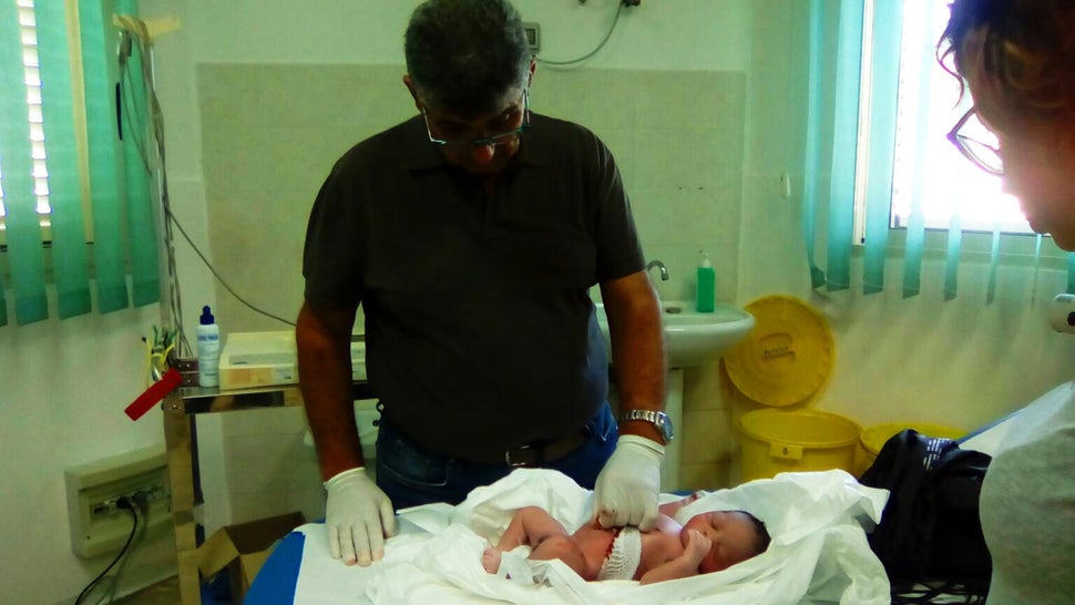 Bartolo with a baby boy from Mali, born on a Lampedusa patrol boat in August. The child was named after the doctor because he