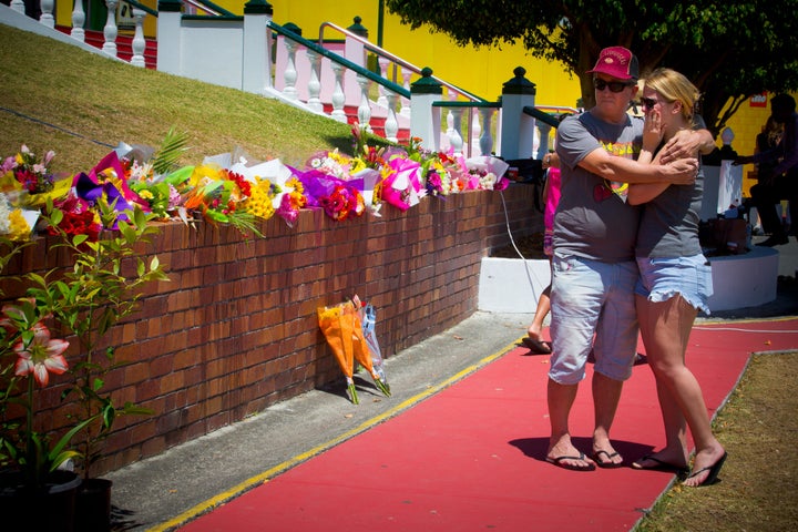 Wayne Marmo hugs his daughter Emily as they lay flowers at a makeshift floral tribute.