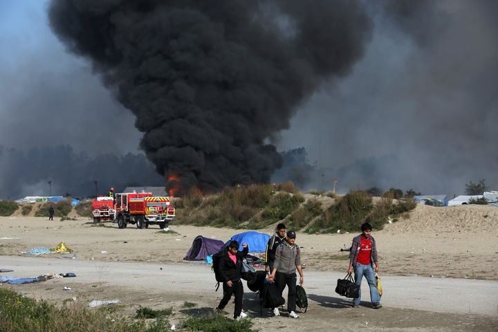 Thick smoke and flames rise from the camp's tents