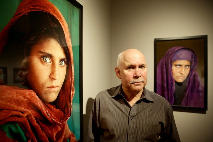 U.S. photographer Steve McCurry beside his famous "Afghan Girl" portrait of Sharbat Gula in 2013. It's been compared to