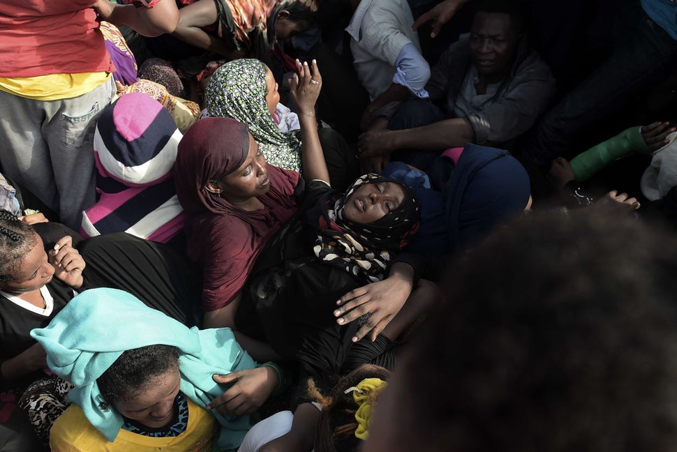 A woman faints while refugees and migrants wait to be rescued in the Mediterranean Sea, some 12 miles north of Libya, on