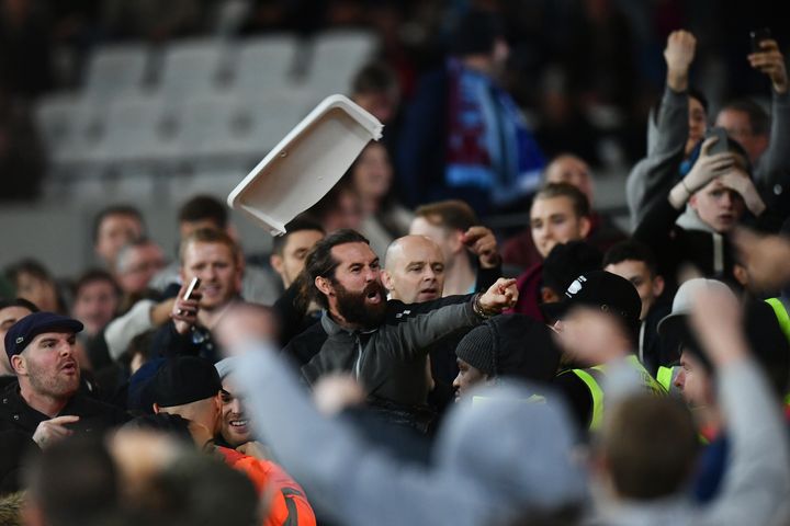 Police arrested seven men after violence broke out when West Ham played Chelsea at the former Olympic Stadium on Wednesday; fans launched seats and coins at each other