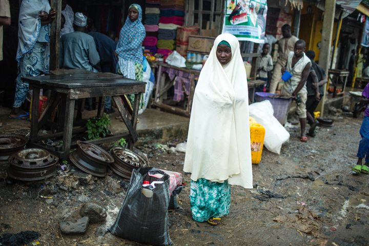 Zulyatu,16, in the market with two bags of food she bought using her e-voucher card. She says there is enough rice in the bag to feed her and her younger siblings for the month.