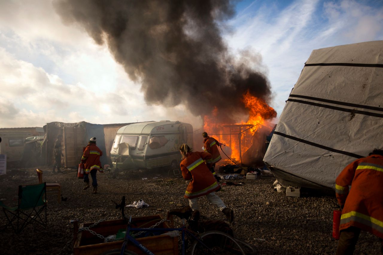 Workers trying to extinguish a tent burning.