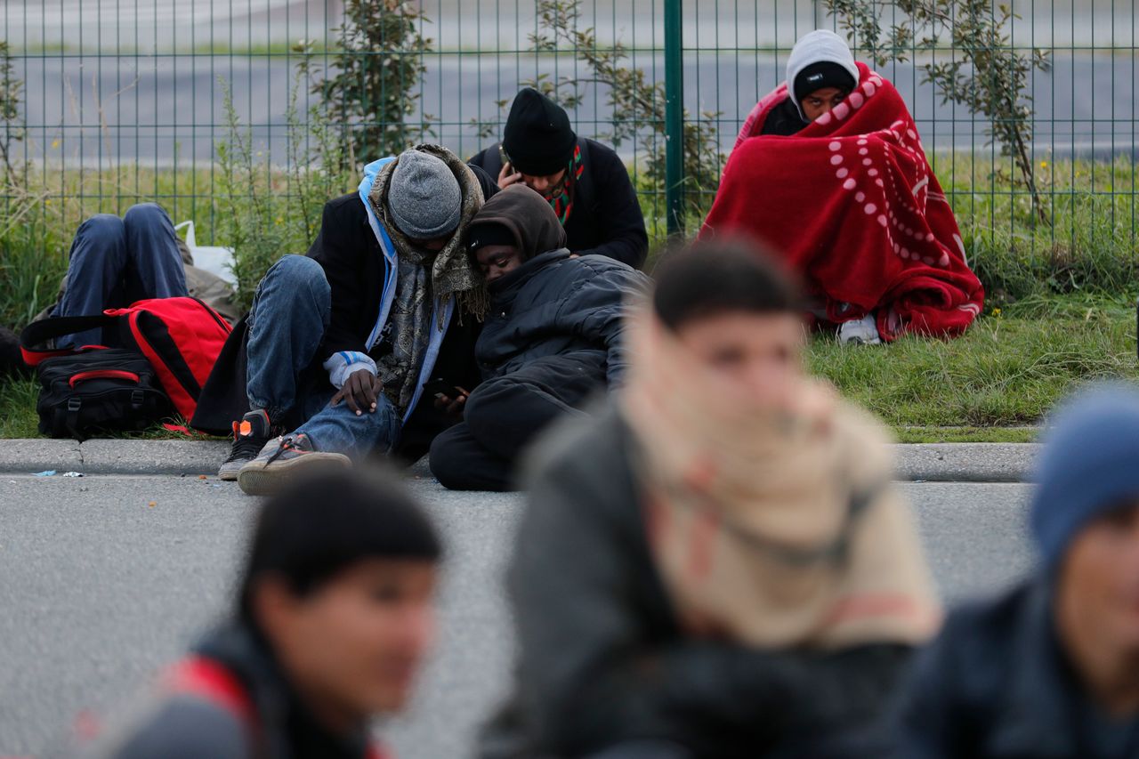 Migrants who say they are minors, use blankets to protect themselves from the cold as they prepare to spend the night on sleeping on the street.