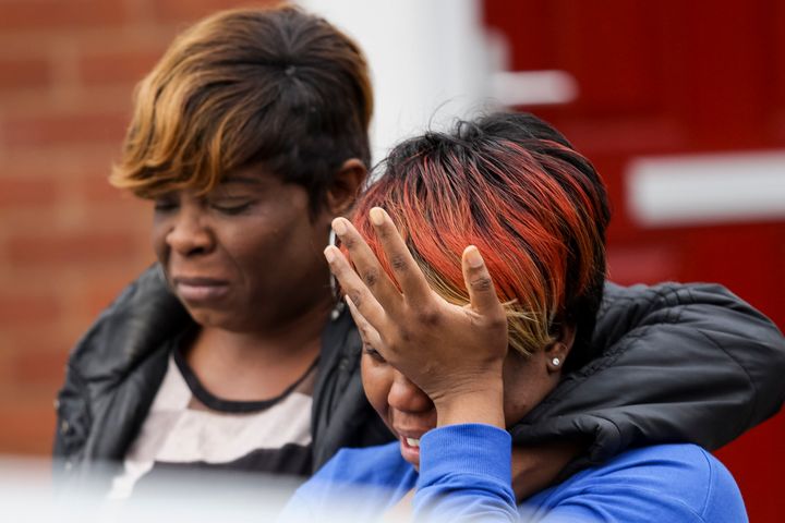 A woman cries as she talks to a police officer at the scene of a house fire in Birmingham that claimed the lives of two children 