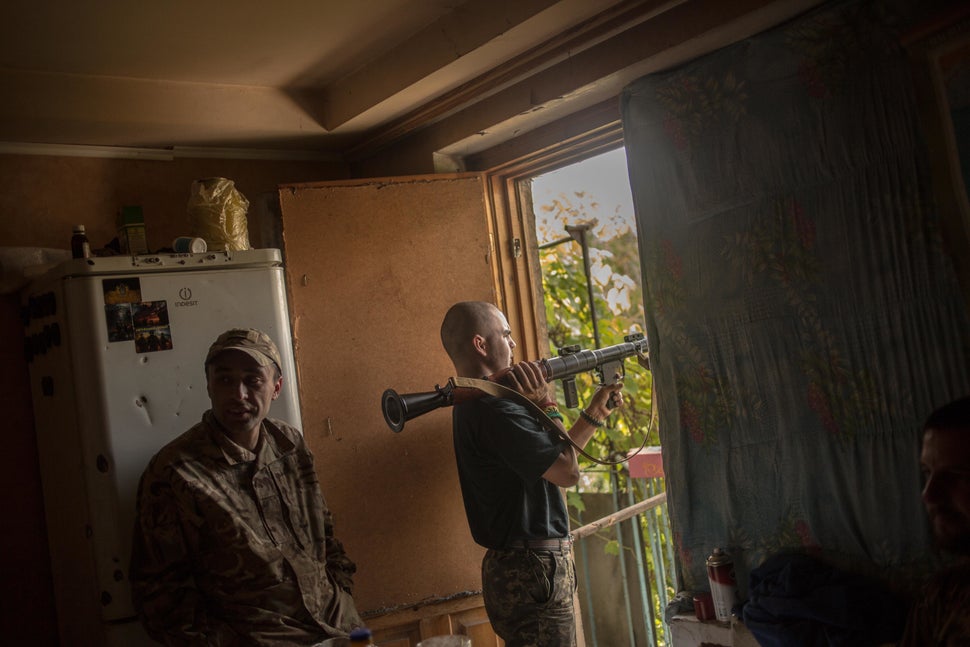 "Little One" inspects the tube of his RPG during the quiet of the daytime as Avram stands to his left. RPGs, automatic grenad