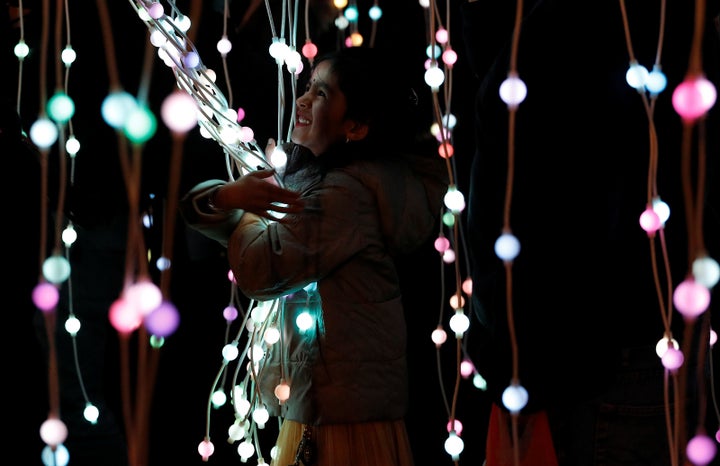 A girl plays in the ocean of lights attraction during the Diwali lights switch on in Leicester, Britain October 16, 2016.