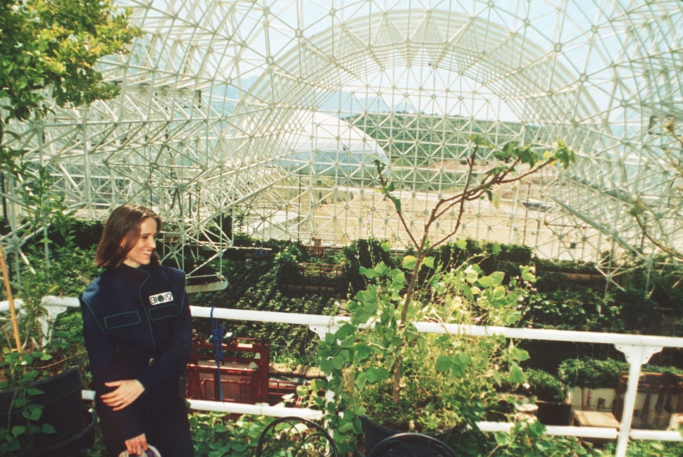 Abigail Alling stands on the balcony of the living quarters inside Biosphere 2 above the agricultural growing area of the com
