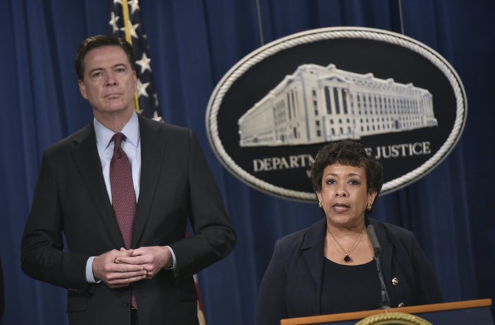 FBI Director James Comey, left, stands alongside Attorney General Loretta Lynch during a press conference at the Department of Justice on March 24, 2016.