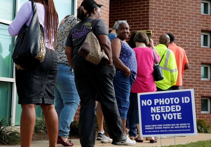 Voters stand in line during early voting at the Beatties Ford Library in Charlotte.