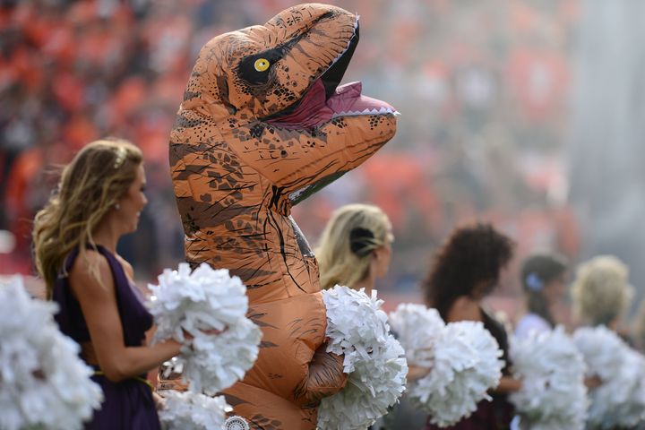 A Denver Broncos cheerleader in a dinosaur costume before the game against the San Diego Chargers on Sunday in Denver.