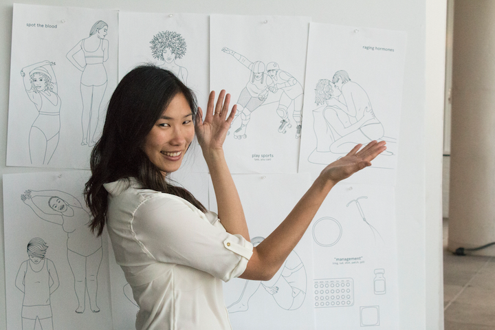 The creator of the Period Coloring Book, Andrea Yip, with her illustrations. 