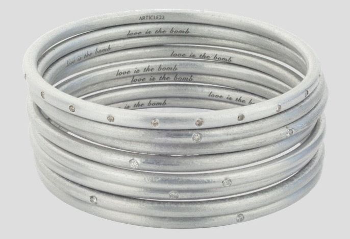 The Article 22 pieces bear messages that allude to the war in Laos. "Love is the bomb" is inscribed on the bangles above.