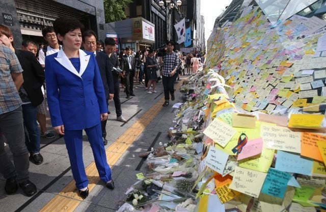 South Korean Gender Minister Kang Eun-hee looks at Post-it messages on the wall of a subway exit in Gangnam, Seoul, South Korea, 20 May 2016, which citizens left to mourn the brutal murder of a 23-year-old woman in an alleged hate crime.