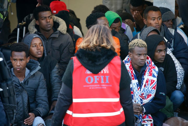 Migrant minors queue to take a bus before their transfer by French authorities to reception centres across the country at the