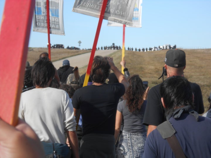 <p>Water protectors approach a line of riot police and armored vehicles on October 15</p>