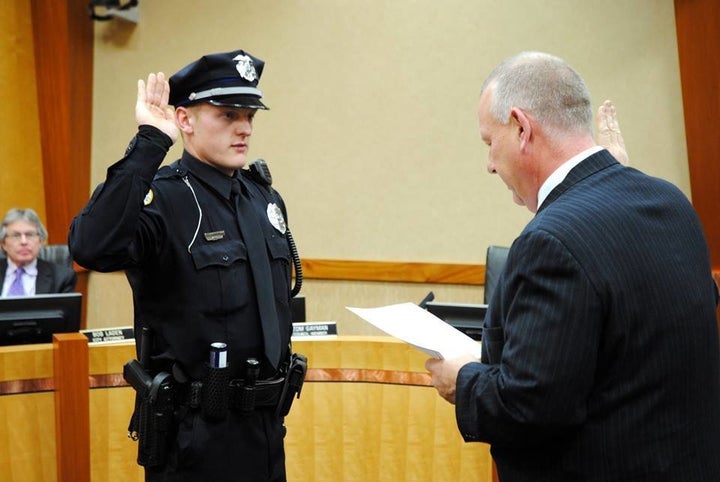 Urbandale Police Officer Justin Martin, one of the two officers killed in Wednesday’s attacks in Iowa, raises his hand as he takes the officer’s oath in January.