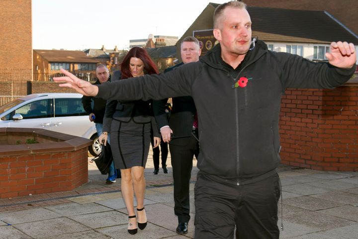 <strong>A member of Fransen's entourage tries to clear a path outside court.</strong>
