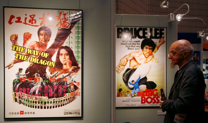 A visitor looks at movie posters during the opening of a Bruce Lee exhibition as part of the Hong Kong International Film Fes