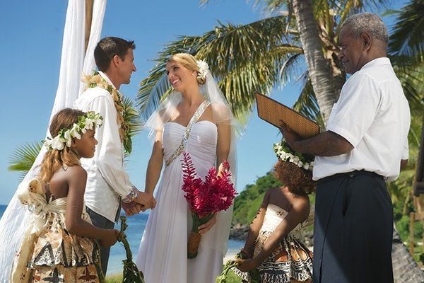 An Authentic Fijian Wedding in Fiji: When you make Fiji your choice for a destination wedding, it typically follows the authentic Fijian format. 1) The couple gets escorted by warrior(s) dressed in grass skirts (called Liku vau) sporting vesa vau (anklets and armbands), and gumu loa (with their faces and cheeks painted black). 2) The couple can be clad in Fijian wedding costumes (or you can skip it) and 3) Flower girl and boy or both girls (traditionally) sprinkle flowers on the aisle leading up to onto the altar where a choir awaits and sings a moving hymn to kick off the nuptials. 