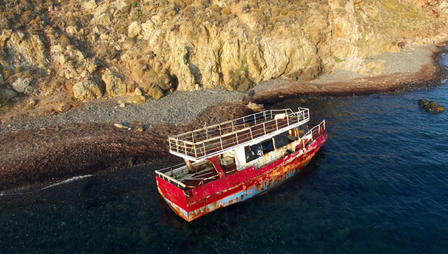 An abandoned boat is seen off the northern coast of the island of Lesbos where thousands of refugees arrived on a daily basis