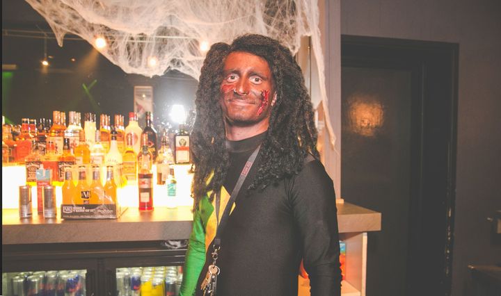 <strong>The photo shows a member of staff in blackface an afro wig and the colours of the Jamaican flag</strong>