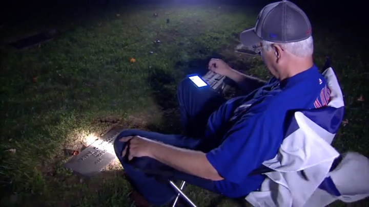 Wayne Williams listens to the World Series at his father's grave in Indiana.