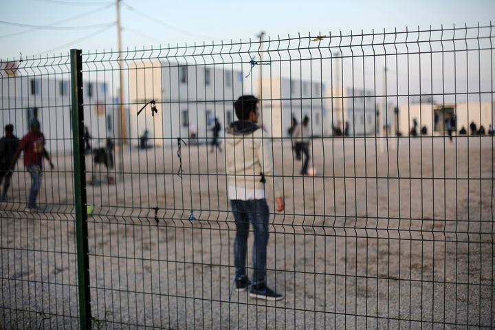 Young migrants play football near the Calais camp