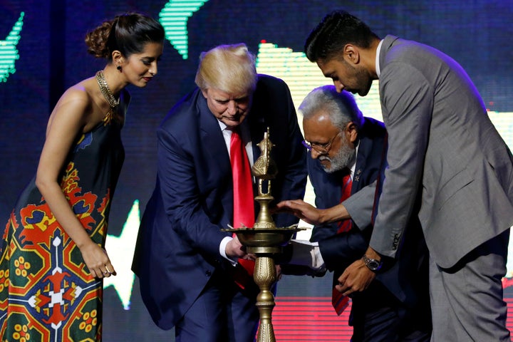 Republican Hindu Coalition Chairman Shalli Kumar (2nd R) helps Republican presidential nominee Donald Trump (2nd L) light a c